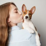young woman kissing her dog