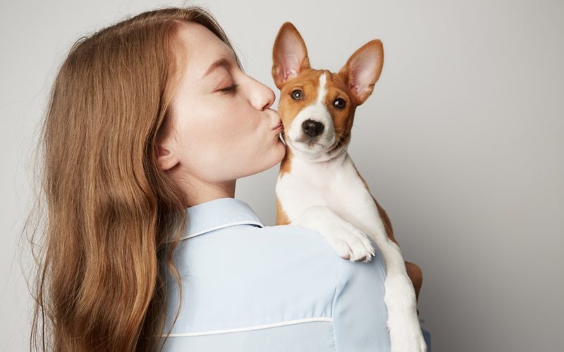 young woman kissing her dog